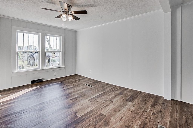 unfurnished room featuring a textured ceiling, visible vents, and wood finished floors