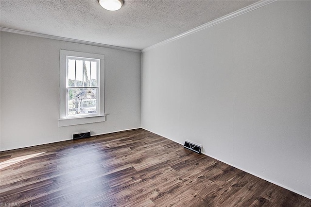 unfurnished room featuring a textured ceiling, ornamental molding, wood finished floors, and visible vents