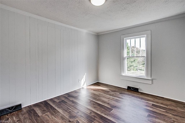 spare room with crown molding, a textured ceiling, visible vents, and wood finished floors