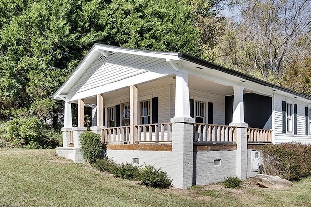 view of front of home with covered porch and a front lawn