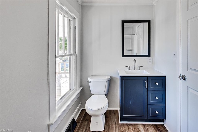 bathroom featuring crown molding, toilet, vanity, wood finished floors, and baseboards