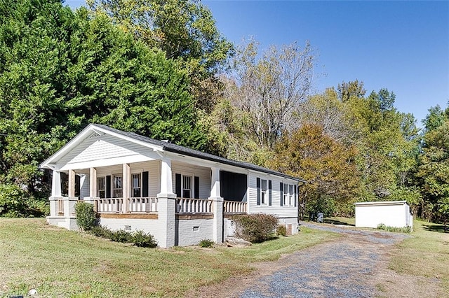 view of front facade with a porch, crawl space, gravel driveway, and a front lawn