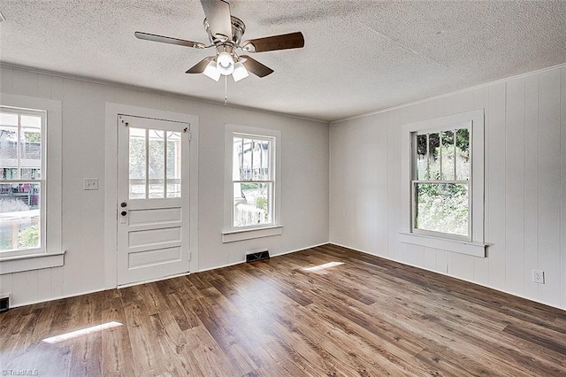 entrance foyer with a wealth of natural light, a ceiling fan, visible vents, and wood finished floors