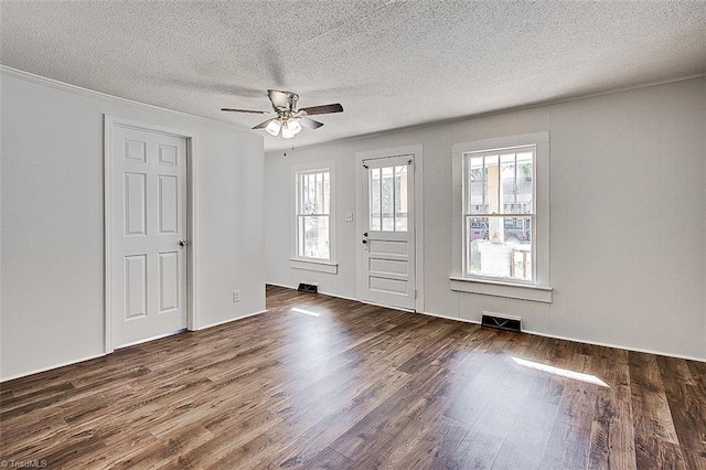 interior space featuring a textured ceiling, dark wood-type flooring, a ceiling fan, and crown molding