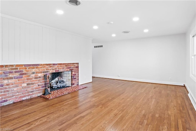 unfurnished living room with a fireplace, recessed lighting, visible vents, light wood-style floors, and baseboards