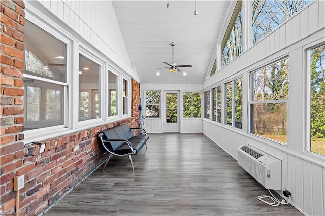 unfurnished sunroom with lofted ceiling, a ceiling fan, and a wall mounted AC