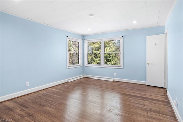 spare room featuring crown molding, baseboards, and wood finished floors