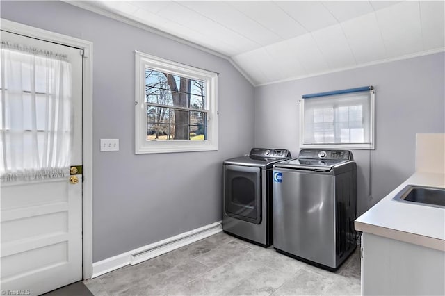 laundry area featuring laundry area, baseboards, a baseboard radiator, independent washer and dryer, and a sink