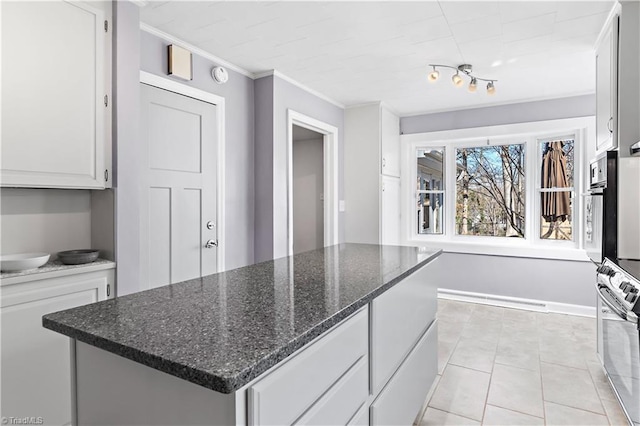 kitchen with a center island, ornamental molding, light tile patterned flooring, white cabinetry, and oven