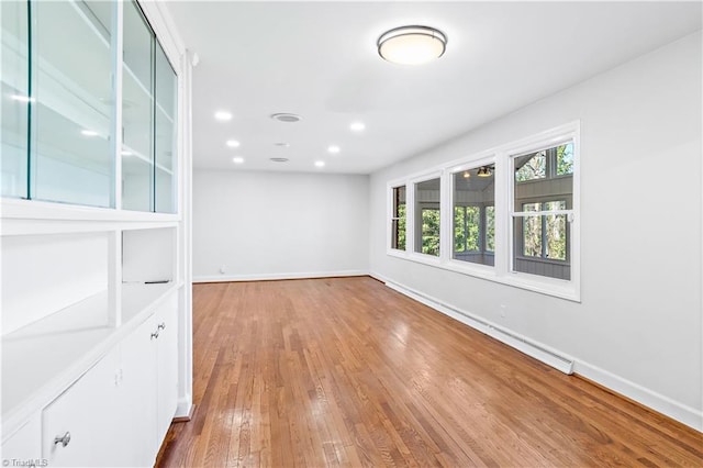 empty room with recessed lighting, hardwood / wood-style floors, and baseboards