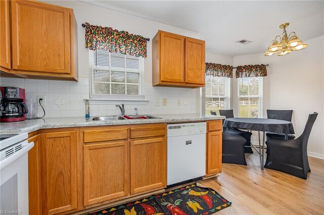 kitchen featuring backsplash, white appliances, light hardwood / wood-style flooring, and a notable chandelier