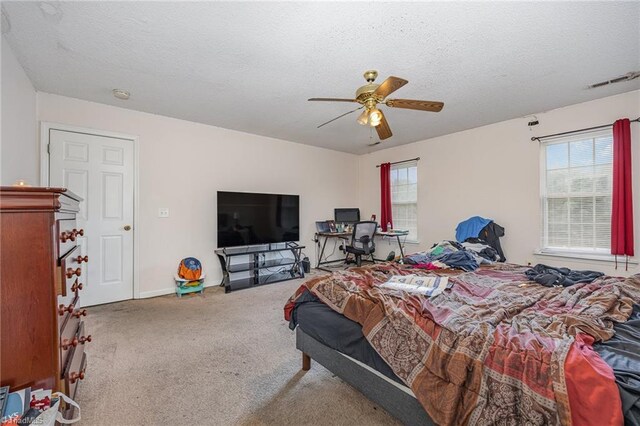 carpeted bedroom featuring a textured ceiling and ceiling fan