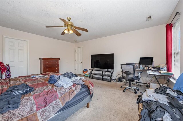 carpeted bedroom featuring ceiling fan and a textured ceiling