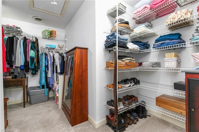 walk in closet featuring light carpet