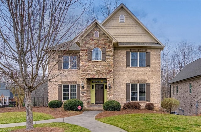 view of front of house featuring stone siding, brick siding, and a front yard