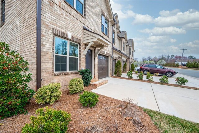914 Bonanza Ln, Mebane, NC 27302 - view of side of property featuring concrete driveway, an attached garage, and brick siding
