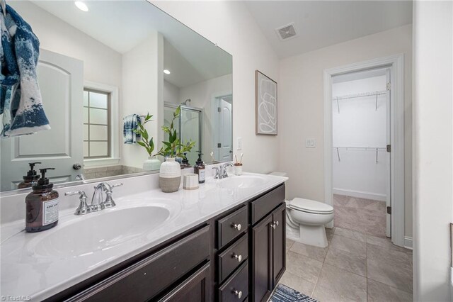 914 Bonanza Ln, Mebane, NC 27302 - full bath with double vanity, a sink, a shower stall, a walk in closet, and toilet