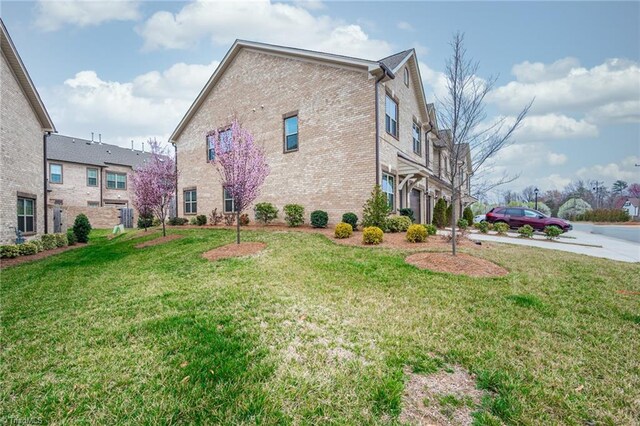 914 Bonanza Ln, Mebane, NC 27302 - view of home's exterior with a lawn and brick siding