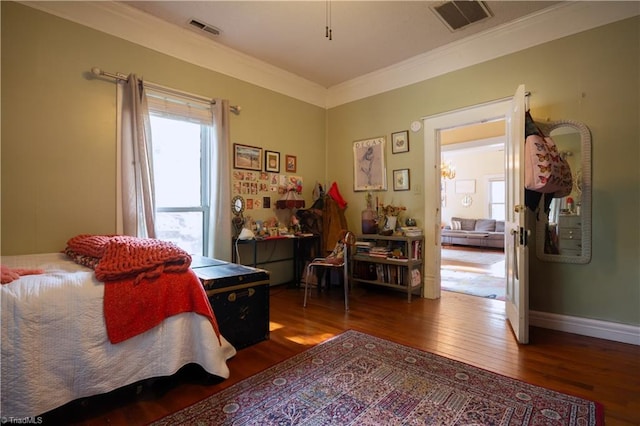 bedroom featuring ornamental molding, hardwood / wood-style flooring, baseboards, and visible vents
