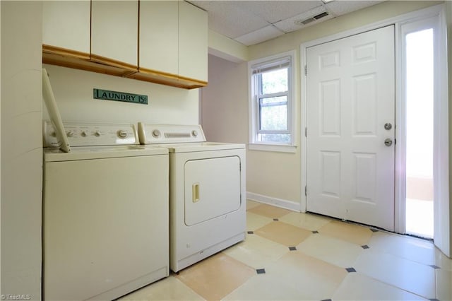 laundry area featuring light floors, baseboards, washer and dryer, visible vents, and cabinet space