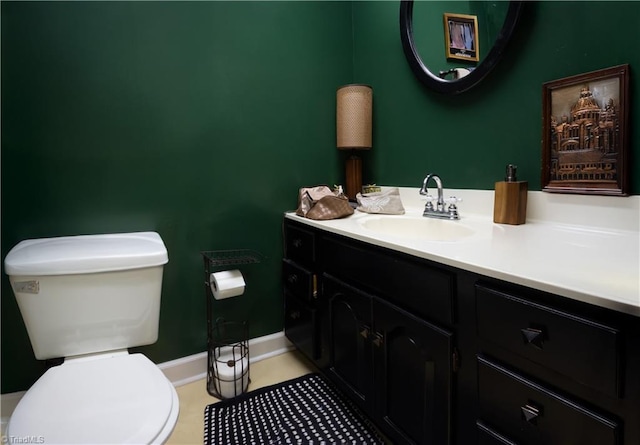bathroom featuring vanity, toilet, baseboards, and tile patterned flooring