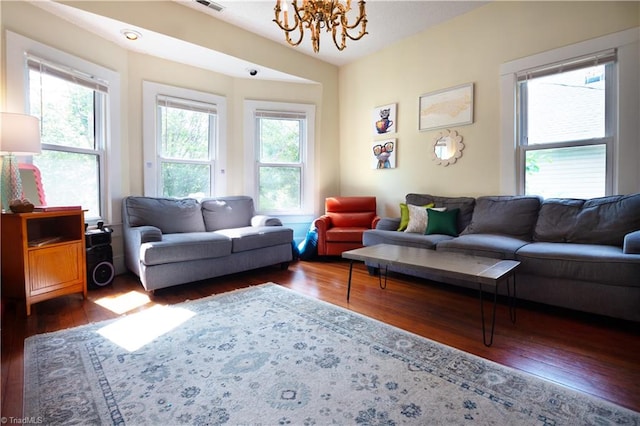 living room featuring a chandelier, visible vents, and wood finished floors