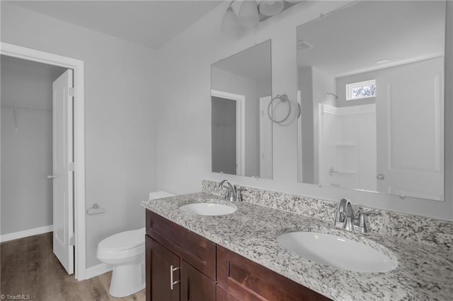 bathroom with toilet, vanity, wood-type flooring, and walk in shower