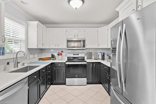 6796 Ironwood Cir, Greensboro, NC 27410 - kitchen with stainless steel appliances, a sink, white cabinets, light countertops, and crown molding