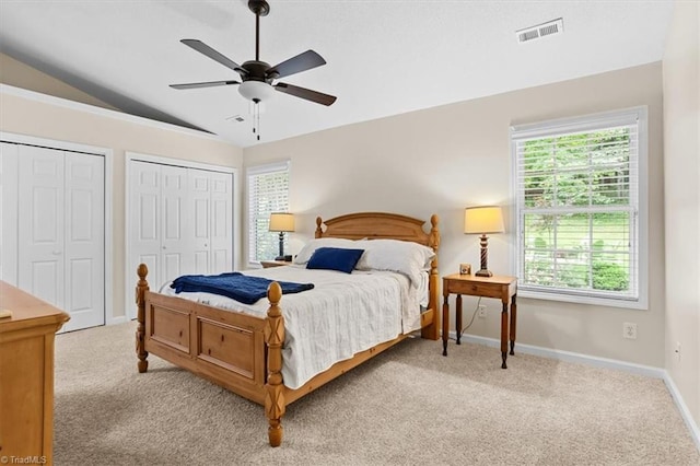 6796 Ironwood Cir, Greensboro, NC 27410 - carpeted bedroom with multiple windows, vaulted ceiling, baseboards, multiple closets, and ceiling fan