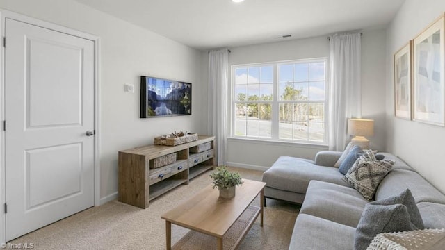 living room featuring baseboards and light carpet