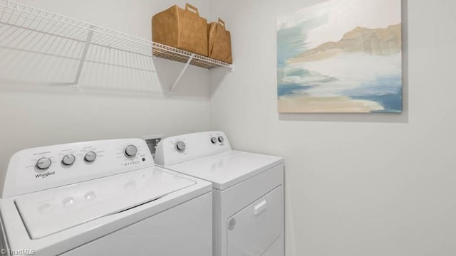 clothes washing area with independent washer and dryer and laundry area