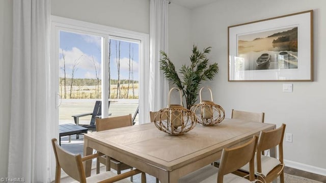 dining space with baseboards and wood finished floors