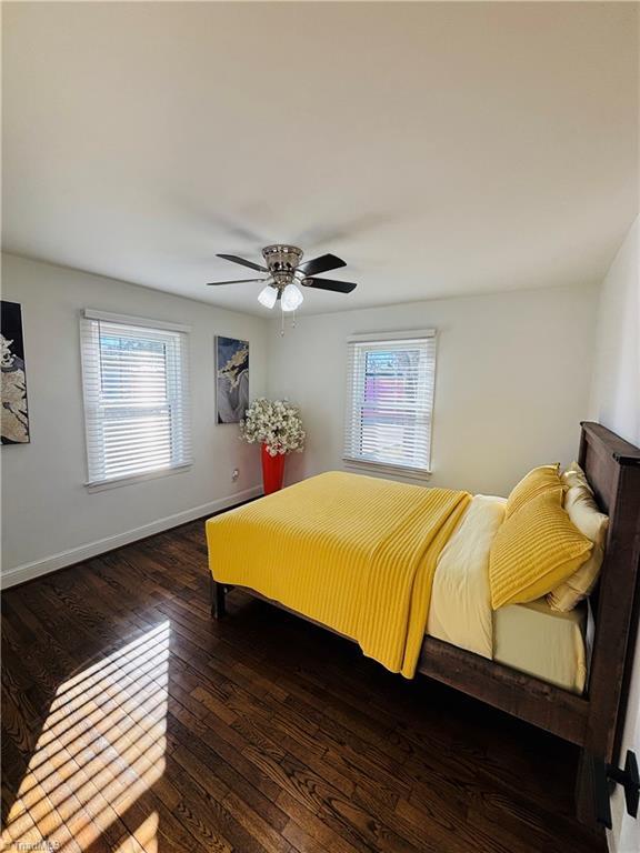 bedroom with dark wood-type flooring and ceiling fan