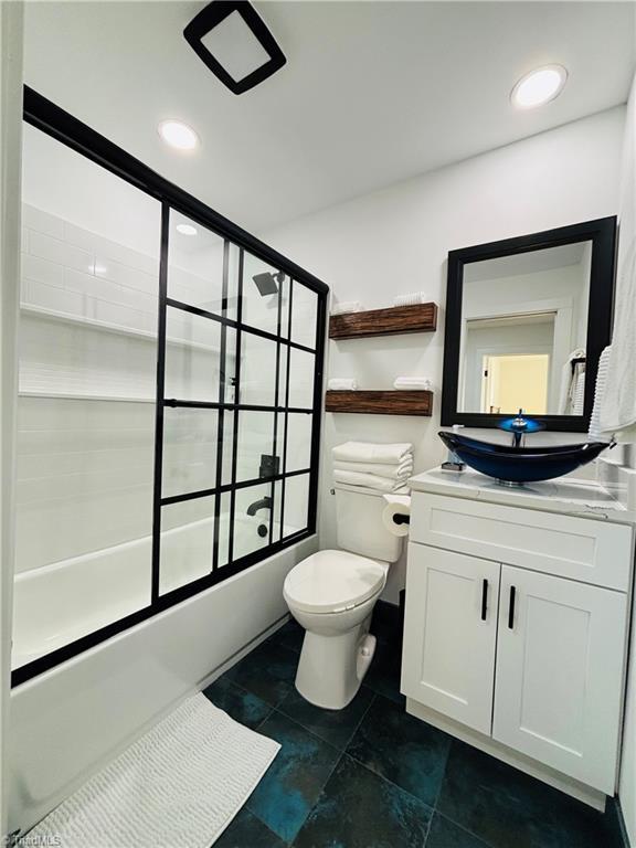 full bathroom with shower / bath combination with glass door, toilet, and vanity