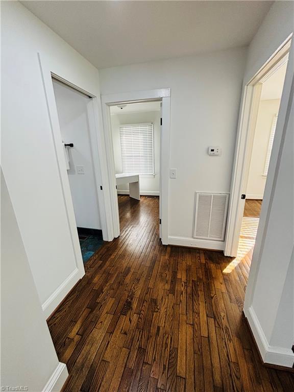 corridor featuring dark hardwood / wood-style flooring