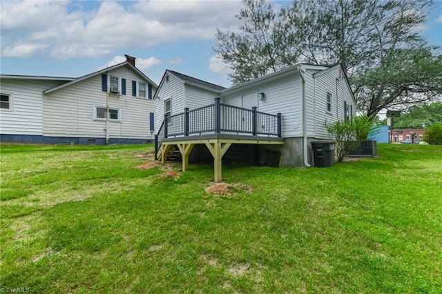 rear view of house featuring a wooden deck and a lawn