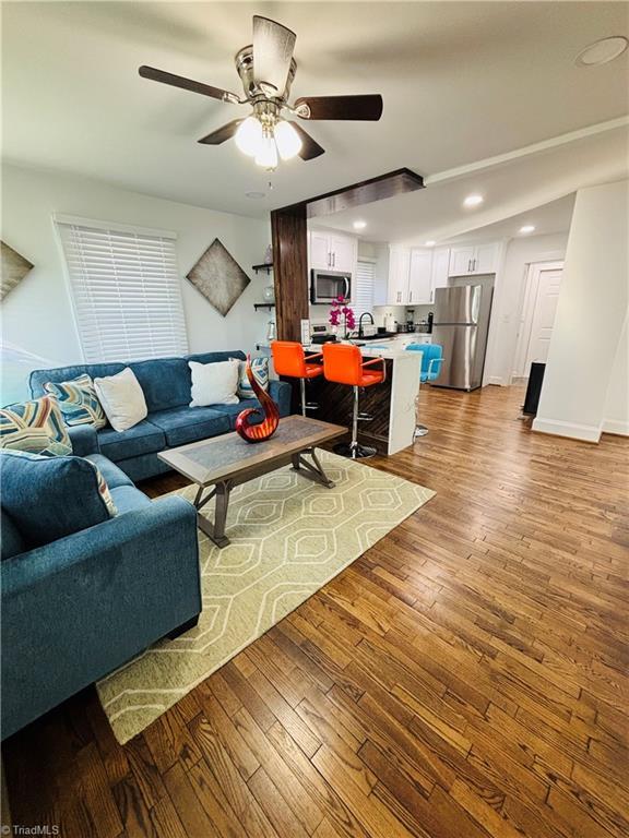 living room with sink, ceiling fan, and hardwood / wood-style floors