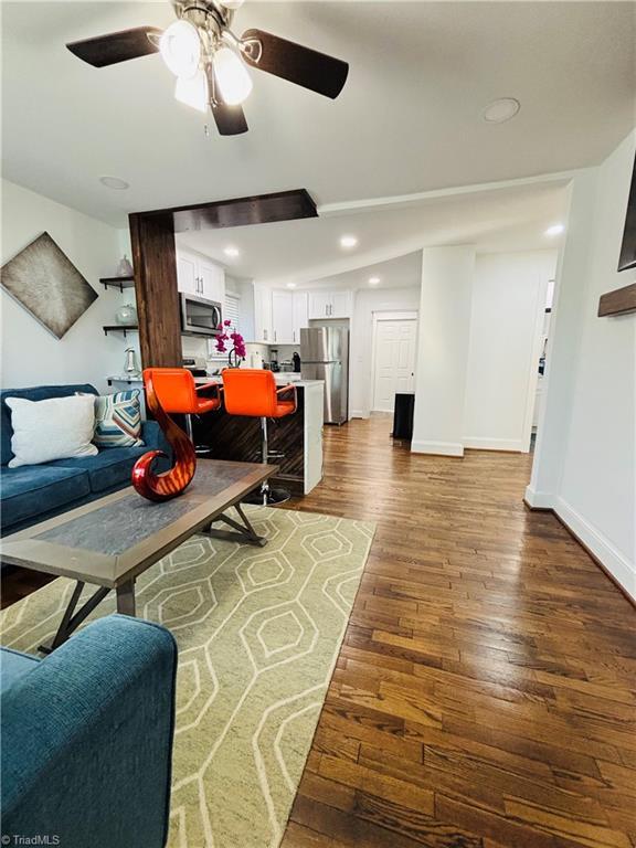 living room with hardwood / wood-style flooring and ceiling fan