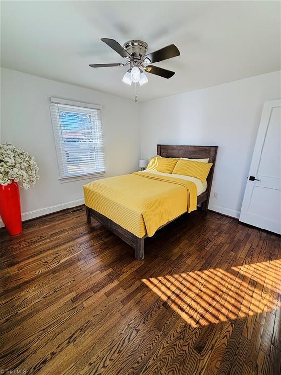 bedroom with ceiling fan and dark hardwood / wood-style floors