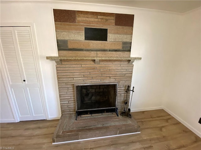 interior details featuring hardwood / wood-style flooring, ornamental molding, and a fireplace