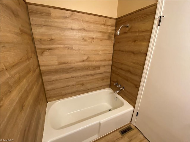 bathroom featuring tile patterned flooring and bathing tub / shower combination