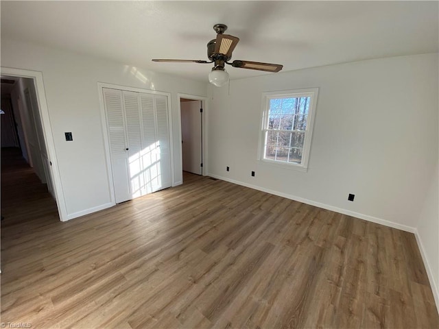 unfurnished bedroom with hardwood / wood-style floors, a closet, and ceiling fan