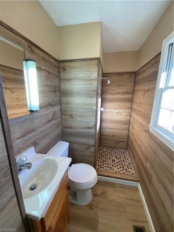 bathroom featuring vanity, a shower, and toilet