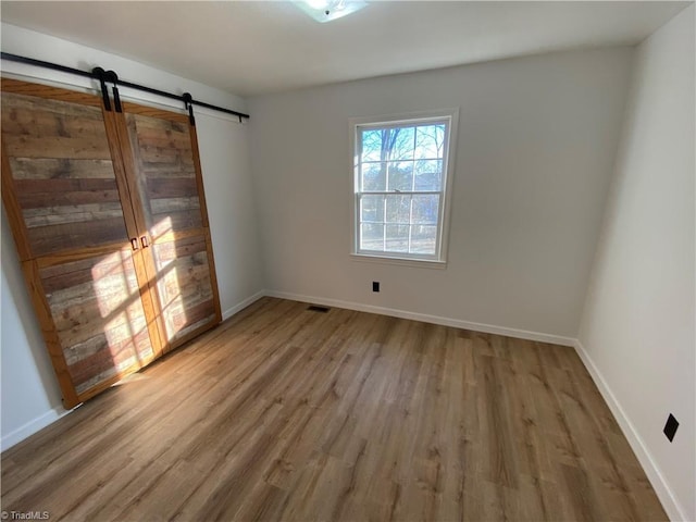 empty room featuring hardwood / wood-style flooring and a barn door