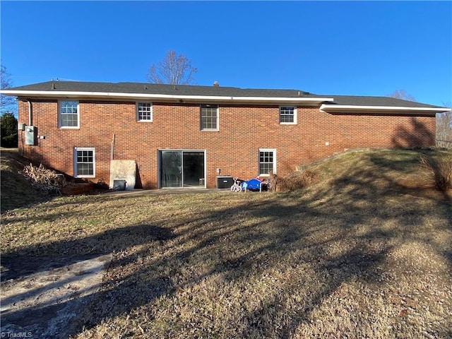 back of property with a yard and central air condition unit