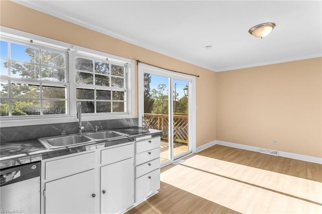 3227 Loftyview Dr, High Point, NC 27260 - kitchen featuring stainless steel dishwasher, a healthy amount of sunlight, a sink, and wood finished floors