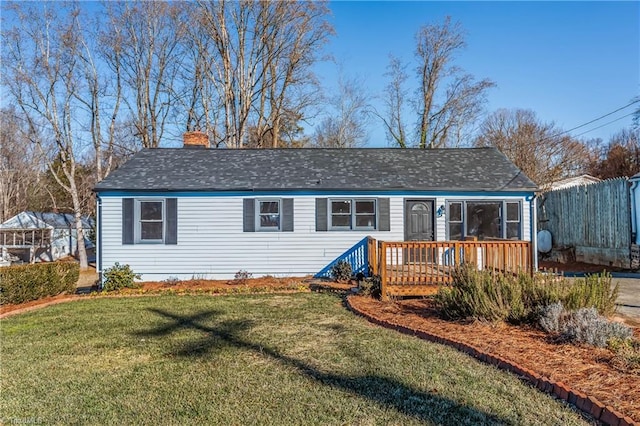 view of front of property with a deck and a front lawn