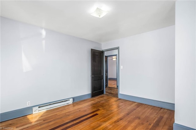 spare room with dark hardwood / wood-style floors and baseboard heating