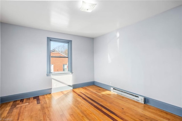 spare room featuring hardwood / wood-style floors and a baseboard radiator