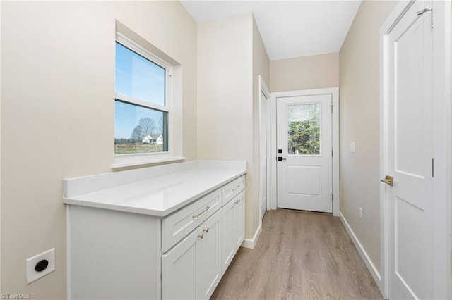entryway featuring baseboards and light wood-type flooring